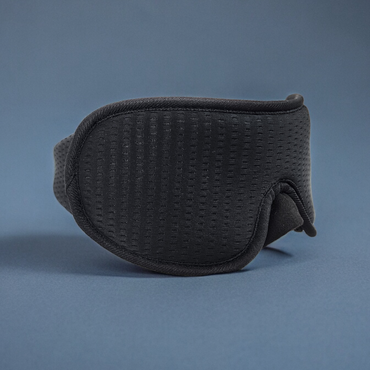Black 3D sleep mask on a blue background