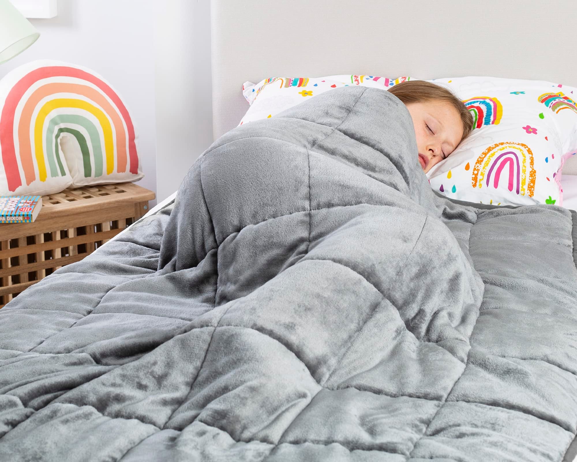 Child sleeping under a silver weighted blanket 