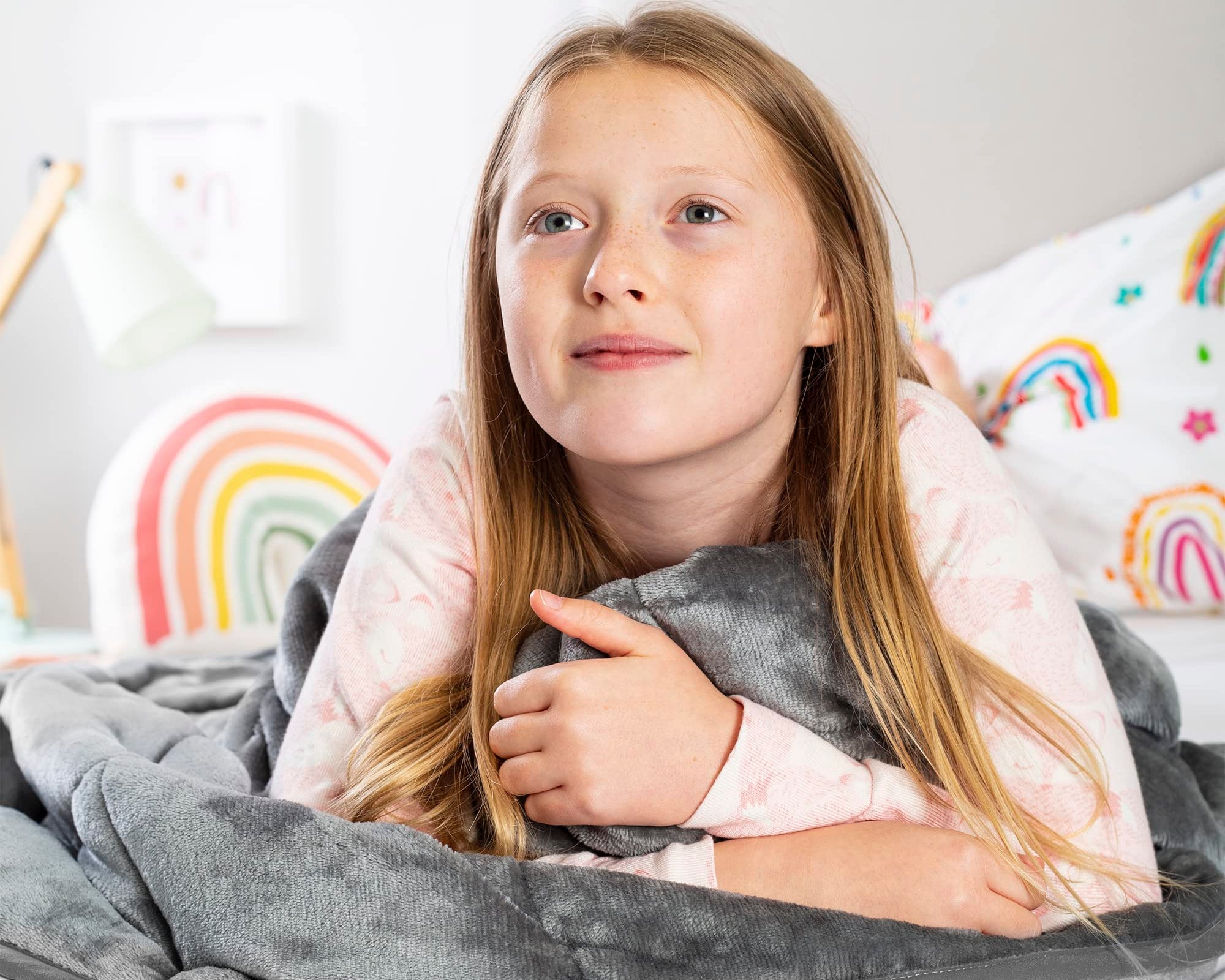 Young girl wrapped in a silver weighted blanket
