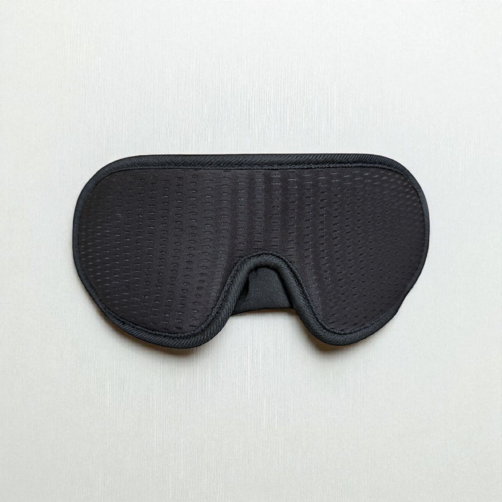 Black 3D sleep mask on a light grey background
